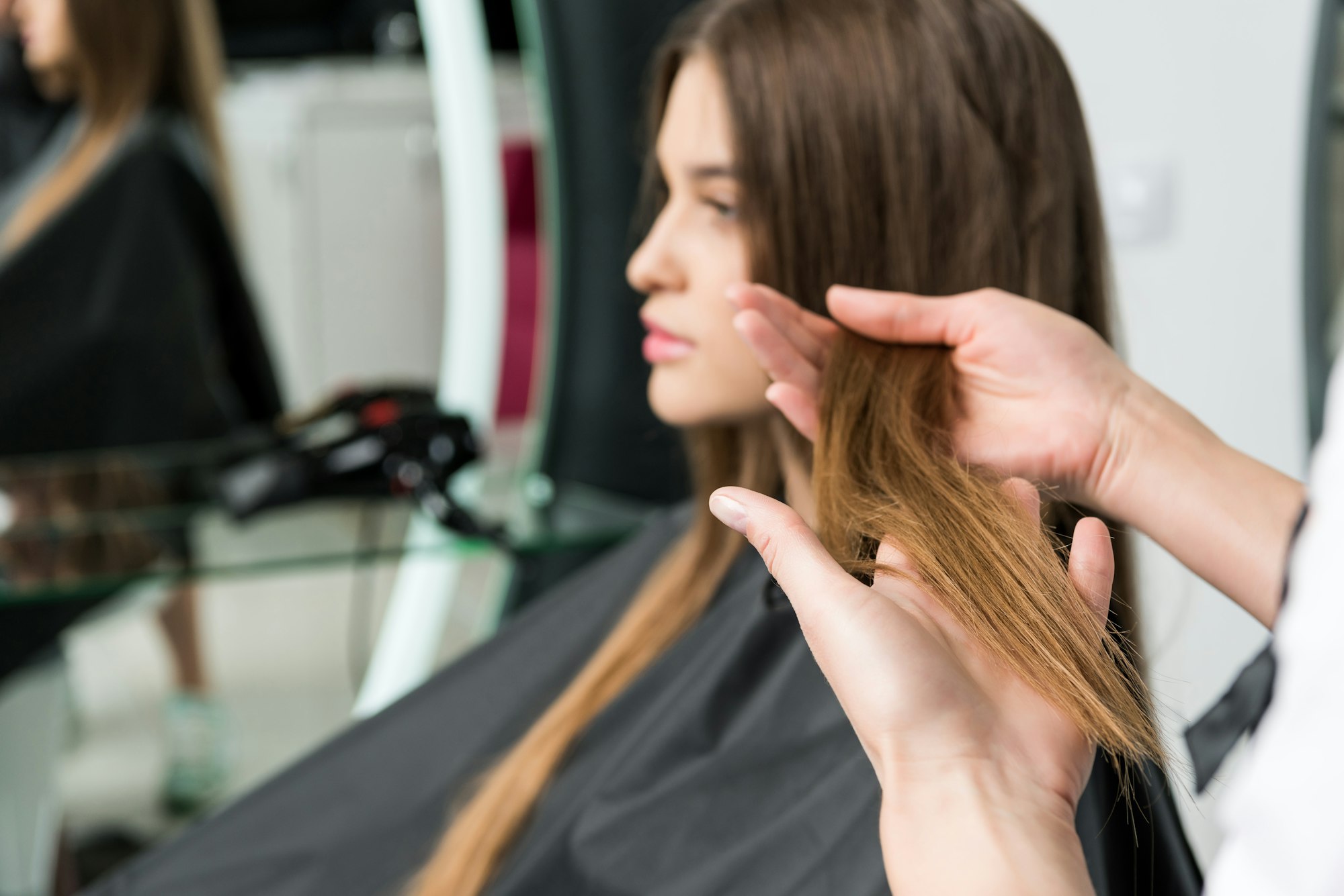 young woman with beautiful hair in hair salon